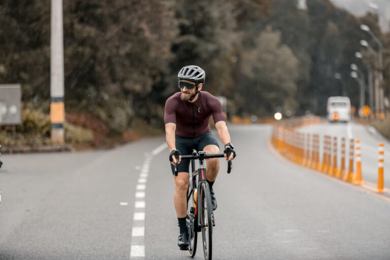 A smiling cyclist riding down the road