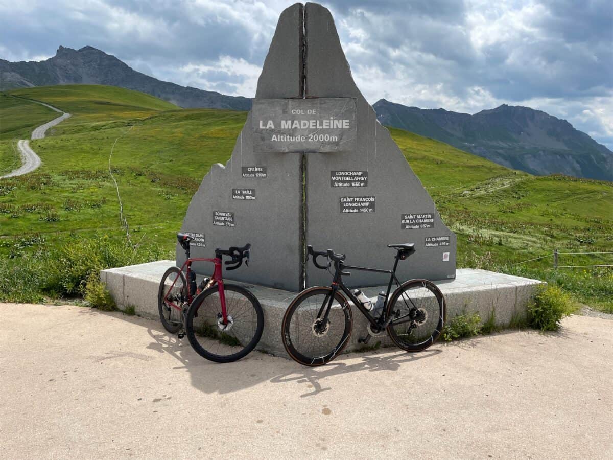 two bicycles leaning against the col de la madeleine summit monument