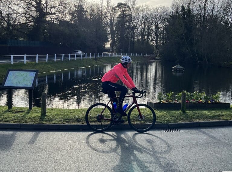 side view of a road cyclist stopped by a pond