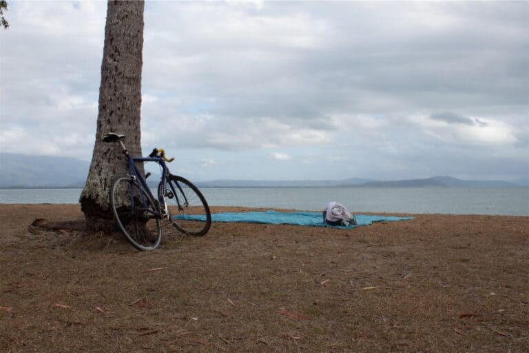 black_bicycle_on_brown_sand_near_body_of_water