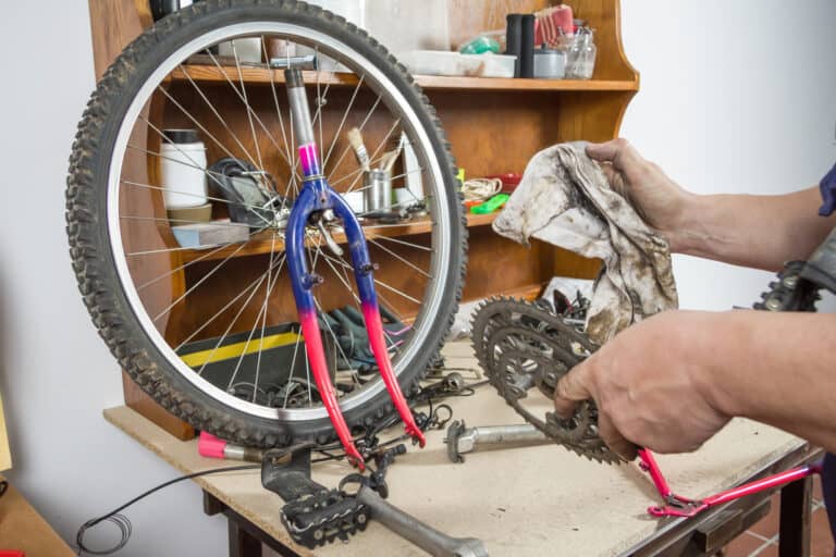 Hands of bicycle mechanic cleaning chainring bike