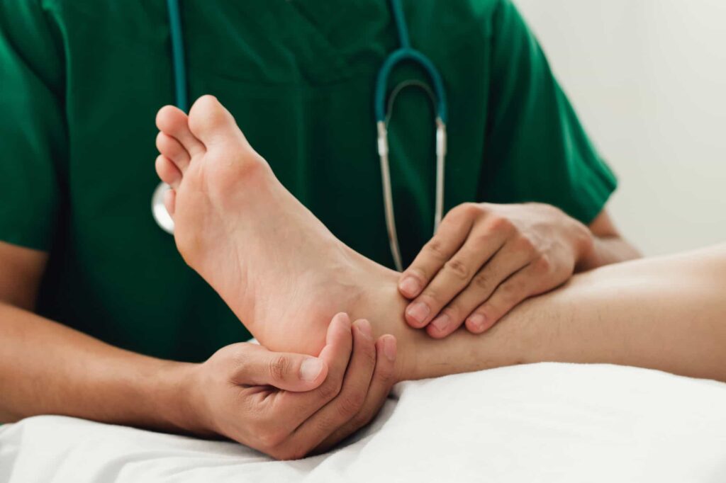 A doctor giving a foot massage to a patient with a sprained ankle.