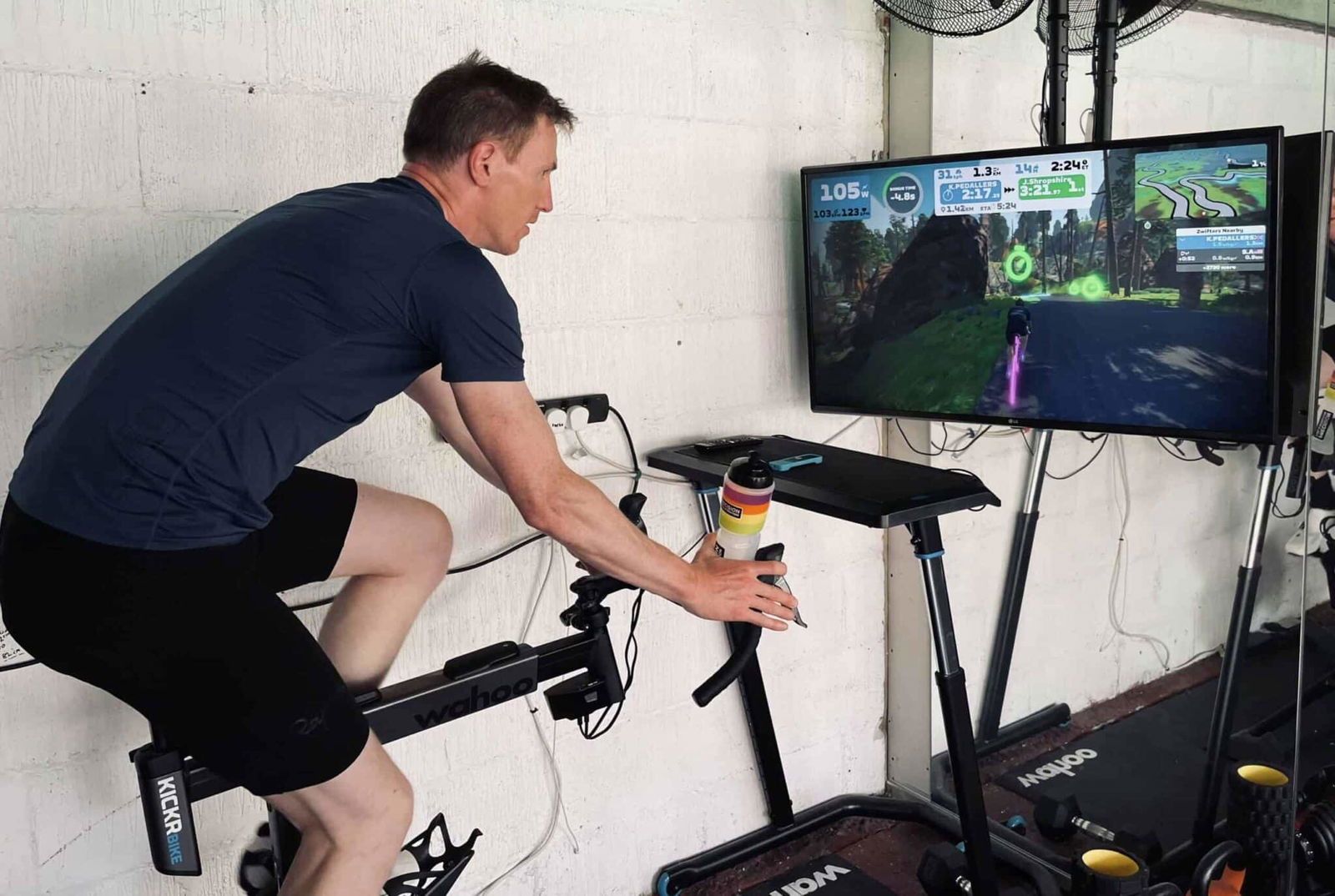 A man playing a video game on an exercise bike.