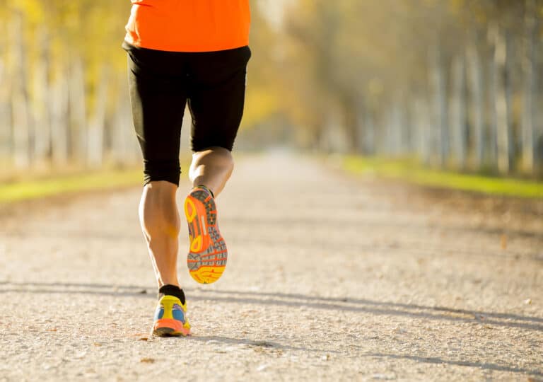 A person is running on a dirt road.