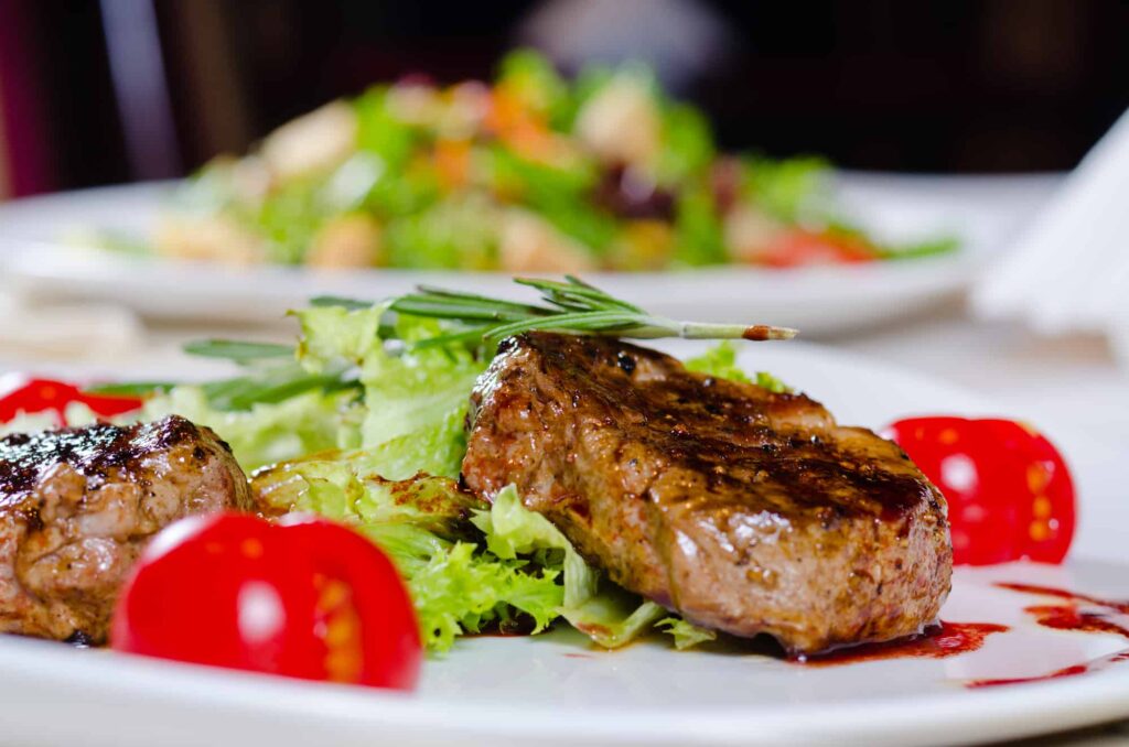 A plate with a steak and salad on it.