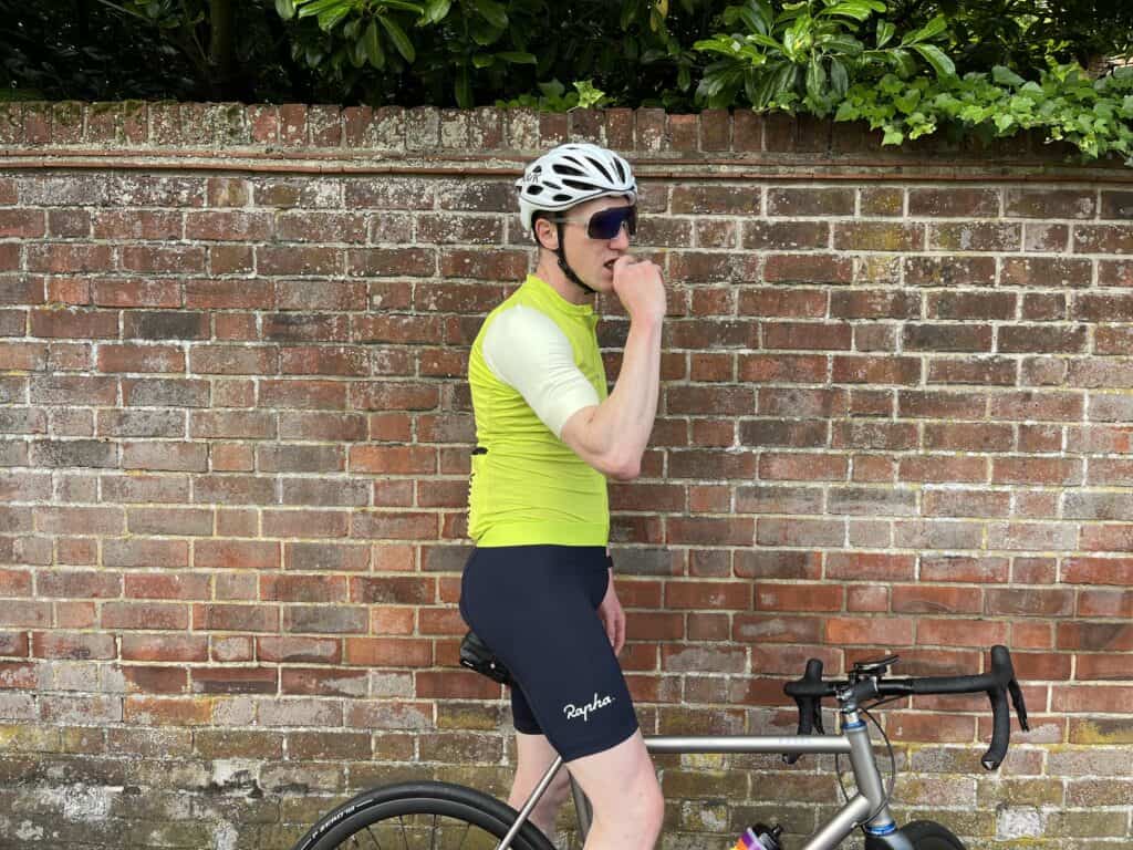 What to eat while cycling : A man with a bike leaning against a brick wall. 